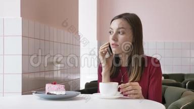 一个年轻漂亮的黑发女孩坐在咖啡馆里，用智能<strong>手机</strong>，<strong>接电话</strong>，打<strong>电话</strong>